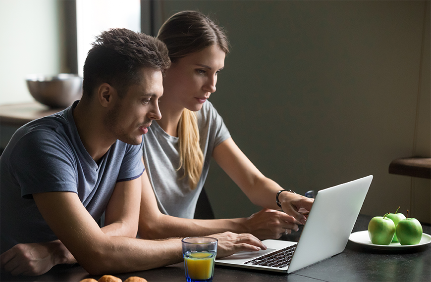 Image of couple on laptop at a table