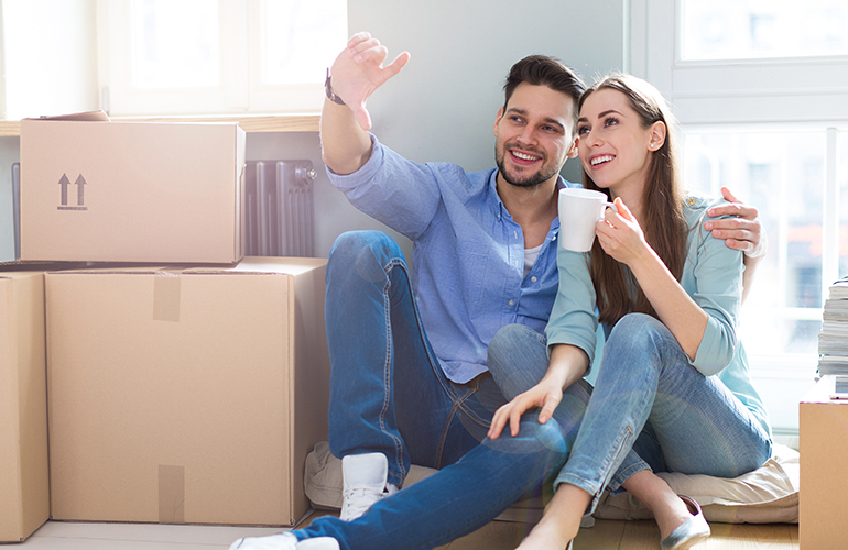 Image of a couple sitting by moving boxes