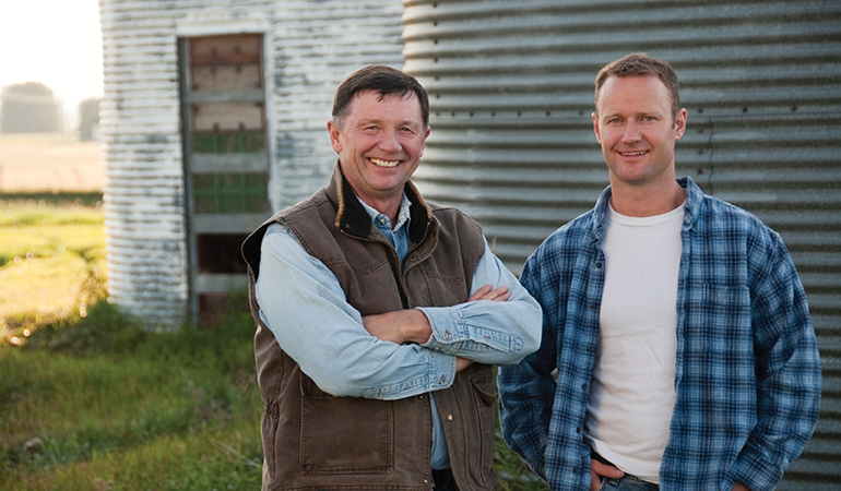 Image of two men standing in front of a silo